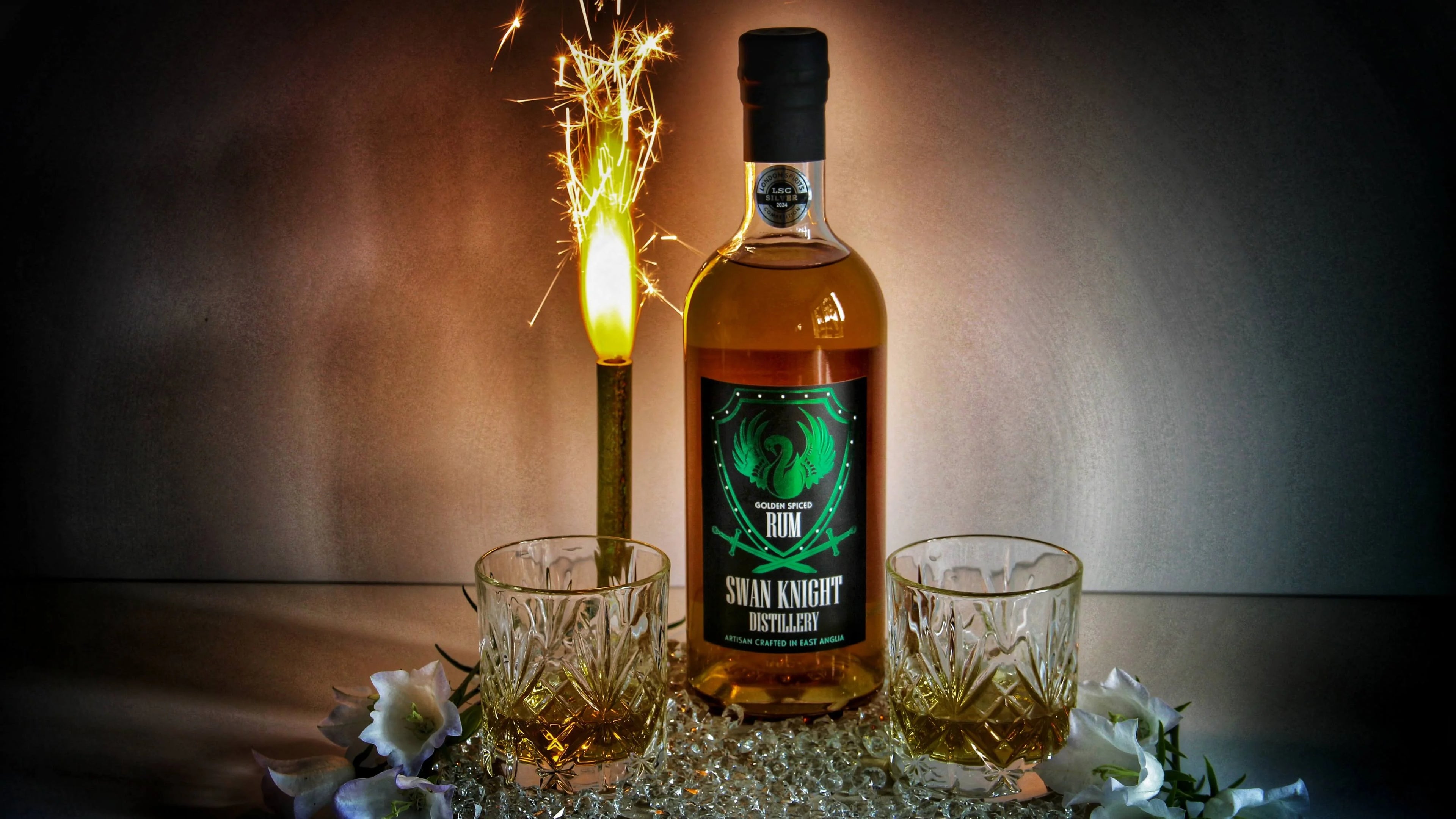 Swan Knight Distillery golden spiced rum with two glasses and a firework to celebrate World Rum Day 2024